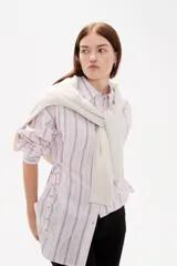 Camisa de viscosa con estampado de rayas verticales, cuello camisero, cierre frontal con botones y detalle de ajuste lateral con cordones.