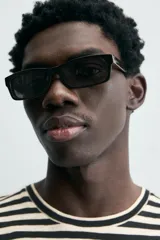 Camiseta de manga corta con cuello redondo y calce relajado, confeccionada en tejido de rayas horizontales blancas y negras.