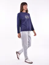 Remera de manga larga color beige, con cuello redondo y estampado frontal que dice "Magic is something you make" en color lila.