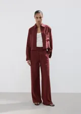 Camisa oversize color borravino, de manga larga con puños abotonados, cuello camisero, dos bolsillos de parche en el frente y cierre delantero con botones.