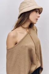 Buzo de punto color tostado con diseño de hombros caídos, cuello amplio y mangas anchas tipo murciélago.