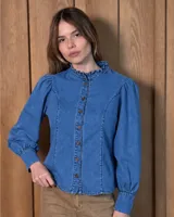 Camisa de jean de corte entallado, con cuello alto con volados, cierre frontal con botones y mangas largas abullonadas con puños ajustados.