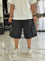 Bermuda de jean estilo cargo con bolsillos laterales con solapa, corte super baggy y lavado efecto desgastado.