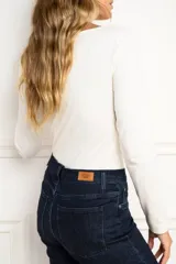 Remera de manga larga ajustada al cuerpo, con cuello redondo, confeccionada en una mezcla de algodón y elastano que aporta suavidad y elasticidad.