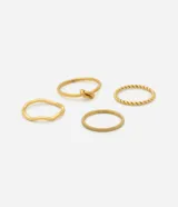 Set de cuatro anillos finos de acero inoxidable en color dorado. El kit incluye un anillo con diseño de nudo, uno de estilo trenzado, uno liso con forma orgánica y uno con acabado texturizado.