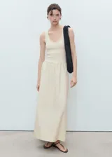 Vestido largo combinado de color marfil, sin mangas, con tirantes anchos, cuello escotado y panel fruncido en la cintura con diseño evasé en la falda.