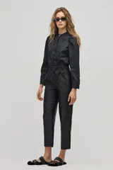 Pantalón sastrero negro de tiro alto con silueta tipo carrot. Tiene cintura ceñida con pliegues en el frente, bolsillos laterales y un bolsillo de ojal en la parte trasera. Confeccionado con taffeta.