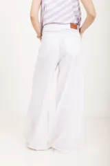 Pantalón de lino blanco de tiro alto, corte wide leg y bolsillos delanteros tipo ojal.