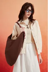 Cartera tipo hobo de gran tamaño en color marrón, con diseño minimalista y correa trenzada en tonos oscuros.