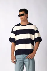 Remera de tejido de punto con diseño de rayas horizontales anchas en color azul marino y blanco, de corte oversize y cuello redondo.