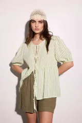 Blusa verde y blanca a rayas verticales, de calce holgado, escote en V con doble lazo ajustable, mangas 3/4 con volumen.