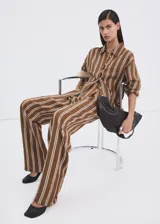 Pantalón tiro medio de corte recto con diseño estampado a rayas, detalle de pinzas, bolsillos laterales y cierre oculto con ganchos y cremallera.