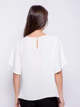 Top rosado de mangas cortas con volados, cuello redondo y detalle diagonal en el frente.