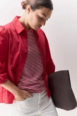 Camisa blanca de algodón, de calce relajado, con cuello camisero, frente abotonado y mangas largas abullonadas.