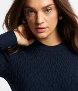 Blusa azul marino de punto con textura de ondas, cuello redondo y mangas largas.