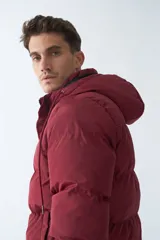 Campera puffer color bordó, con capucha ajustable y cierre frontal con cremallera.