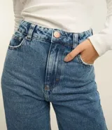 Pantalón de jean celeste de corte wide leg, cintura alta con elástico negro y pespuntes contrastantes.