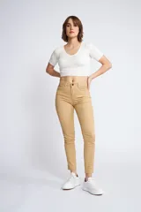 Pantalón de gabardina corte skinny, color beige, con diseño de cinco bolsillos, cierre de cremallera y botón frontal.