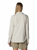 Camisa de senderismo de manga larga en color beige, con cuello clásico, cierre frontal con botones y bolsillos funcionales en el pecho. Cuenta con tecnología de protección solar y ventilación trasera para mayor transpirabilidad.