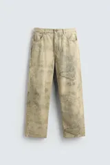 Pantalón de corte baggy fit confeccionado en tejido de algodón con textura. Presenta un diseño de cinco bolsillos, cierre frontal con cremallera y botón, y un acabado con efecto lavado desgastado.