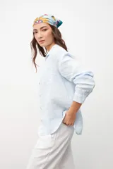 Camisa de lino en color celeste, con cuello clásico, cierre frontal de botones y bolsillo en el pecho.