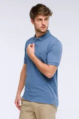 Remera polo de manga corta en tejido piqué color celeste. Presenta cuello clásico con botones, bordado pequeño en el pecho y detalles en tela oxford en el interior del cuello.