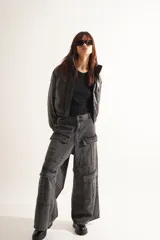 Pantalón jean cargo wide leg color gris oscuro, de tiro medio/bajo con pierna y bota ancha. Tiene cuatro bolsillos grandes en las piernas y largo a los tobillos.