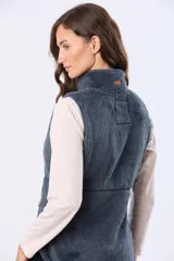 Chaleco de tejido sherpa color beige, con cuello alto y detalles en eco cuero. Diseño sin mangas que proporciona abrigo al torso manteniendo la libertad de movimiento.