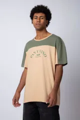 Remera de algodón con diseño color block, combinando tonos beige y verde militar. Presenta cuello redondo y estampa frontal con la frase 'Pan y Vino' y el logo 'VCP Argentina'.