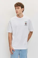 Remera blanca de algodón con cuello redondo, manga corta y pequeño estampado en el pecho.