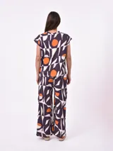 Remera blanca de manga corta con cuello redondo y un estampado abstracto en blanco y negro.