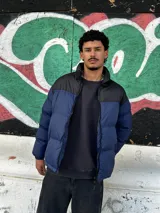 Campera puffer azul con canesú negro y cierre frontal.