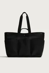 Bolso shopper negro fabricado en tejido técnico, con compartimento principal con cierre de botón a presión, múltiples bolsillos exteriores frontales, doble asa de mano y asas largas de hombro.