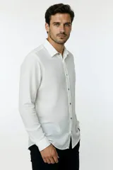 Camisa de poliéster color marrón, de corte holgado, con mangas largas, cuello camisero clásico y cierre frontal de botones.