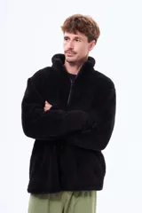 Buzo de sherpa de textura suave y cálida, con cuello alto y cierre frontal parcial. Presenta un diseño de manga larga y corte holgado.