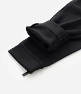 Pantalón deportivo de corte slim para hombre, confeccionado en poliéster color negro. Presenta cintura elástica con cordón de ajuste, bolsillos laterales y diseño ajustado en muslos y rodillas.