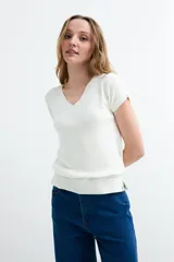 Sweater de tejido de punto color blanco, de manga corta, con escote en V y diseño clásico.