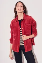 Sobrecamisa de pana color rojo, con cierre frontal de botones, bolsillos delanteros con solapa y ruedo desflecado.