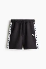 Short de felpa de mezcla de algodón en color negro, con corte regular fit, cintura elástica con cordón de ajuste y bolsillos laterales. Presenta franjas laterales blancas con el logotipo de la marca repetido y el logo de Lotto bordado en la pierna izquierda.