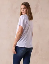 Remera blanca de lino con mangas cortas y fruncido en los hombros.