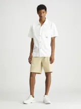 Bermuda color beige de algodón regenerativo, con cintura elástica, bolsillos laterales y traseros.