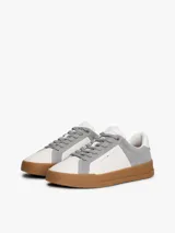 Zapatillas de tenis Tommy Hilfiger de corte bajo, confeccionadas en piel nobuk con paneles de texturas mixtas en blanco y gris. Presentan suela de goma color caramelo, cierre con cordones y detalles distintivos de la marca en la lengüeta, lateral y talón.