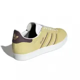 Championes adidas modelo Gazelle, confeccionados en gamuza color amarillo con las icónicas tres tiras laterales en marrón. Presentan suela de goma blanca, lengüeta blanca y detalle en el talón en color marrón oscuro.