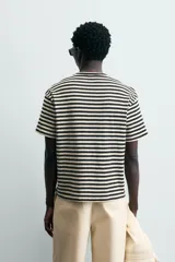 Camiseta de manga corta con cuello redondo y calce relajado, confeccionada en tejido de rayas horizontales blancas y negras.