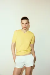 Jersey de punto liso confeccionado en lana, con cuello en pico y manga corta.