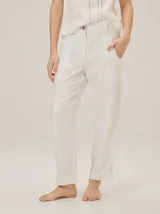 Pantalón barrel de lino y poliéster color blanco, de corte holgado, con bolsillos laterales y detalles de costuras pespunteadas.