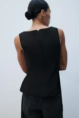 Top peplum blanco de manga sisa, con escote cuadrado y cierre de cremallera oculta en la espalda.