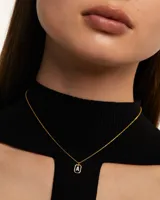 Collar dorado con dije rectangular con borde facetado y letra A con incrustaciones de circonitas.