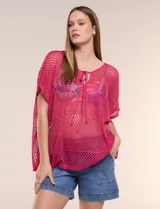 Poncho fucsia de Do Everything In Love, confeccionado en tejido calado de poliéster. Presenta cuello redondo con cordones para ajustar y aberturas laterales.