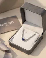 Gargantilla de plata 925 estilo tenis, compuesta por una cadena de circonias blancas brillantes y un dije central en forma de tambor con circonias azules.